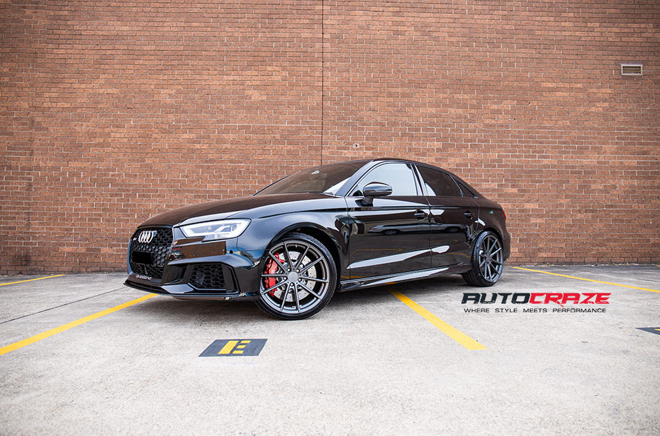A sleek black Audi RS3 sport sedan parked on a concrete surface, showcasing image.