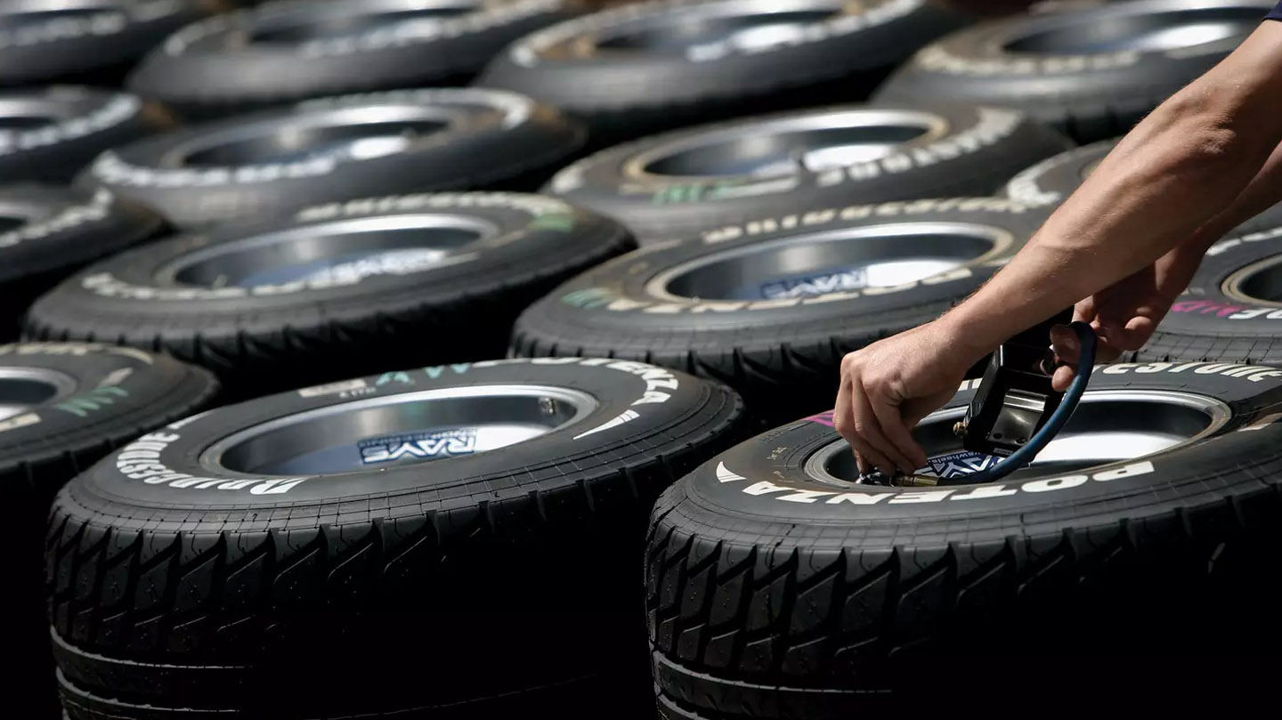 Image of someone checking the tyre pressure on tyres.